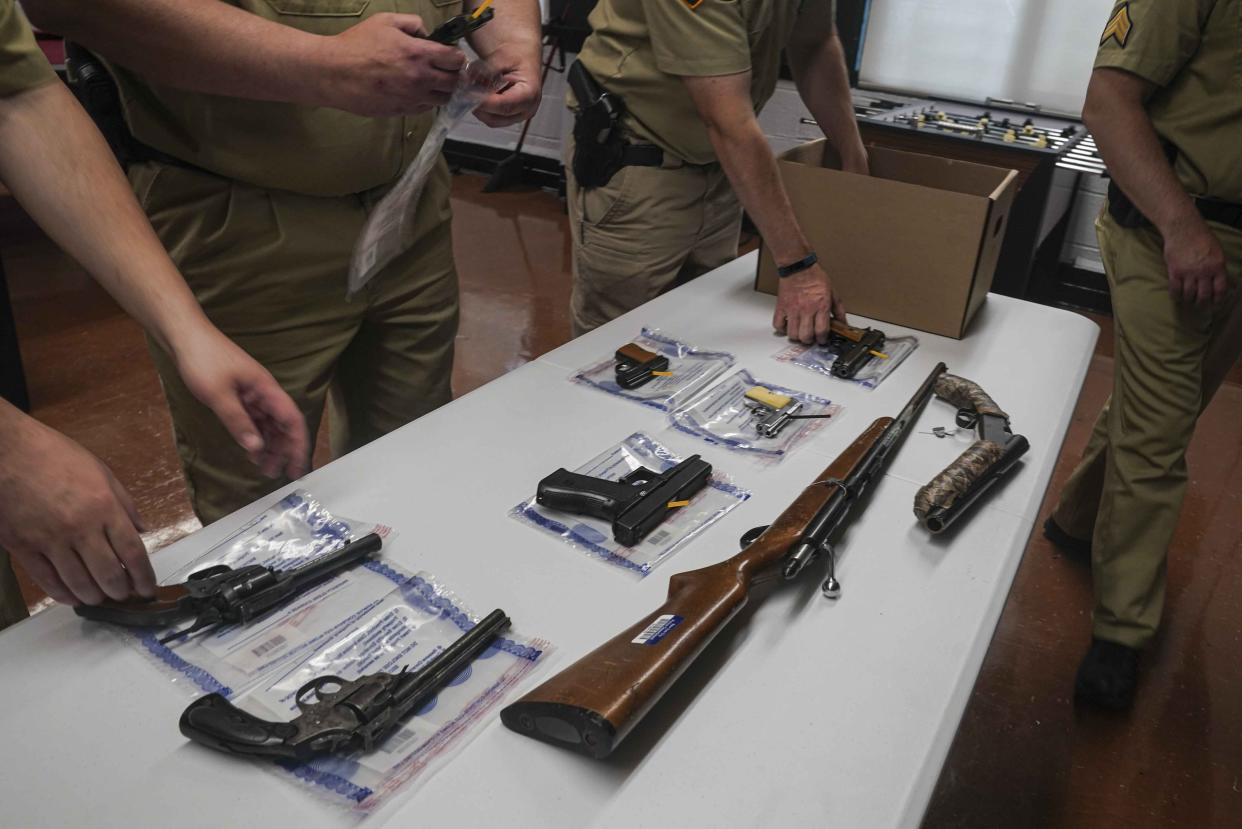 FILE - In this May 22, 2021, file photo officers from the NYPD firearm and tactical unit pack collection of illegal guns after a gun buyback event in Brooklyn, N.Y. Gun violence is on the rise across the country and law enforcement agencies are struggling with how to manage the spikes, especially in cities. The federal government has stepped in with strike forces and other measures help to stop the sale of illegal weapons. (AP Photo/Bebeto Matthews, FIle)