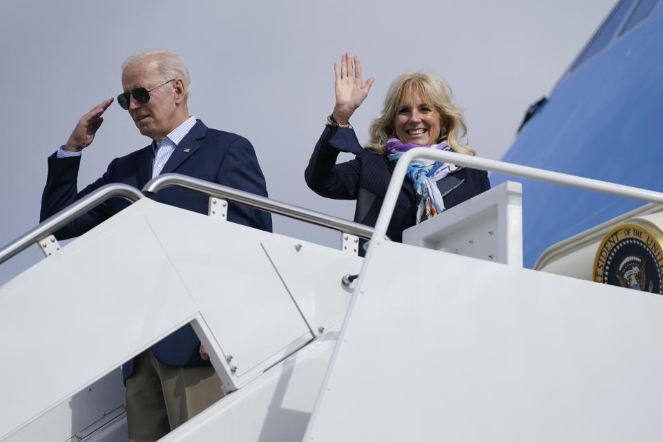 President Biden salutes and first lady Jill Biden waves before boarding Air Force One for a trip to Rome to attend the G-20 meeting.