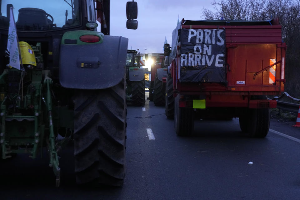 A truck has a banner reading "Paris, we arrive" on a blocked highway, Thursday, Feb.1, 2024 in Argenteuil, north of Paris. France's two major farmers unions announced they would lift country-wide blockades Thursday, shortly after the prime minister introduced new measures aimed at protecting their livelihoods that they described as "tangible progress." However, farmer activists who have snarled traffic along major highways around Paris said they would stay put at least another day to see the government commitments in writing. (AP Photo/Michel Euler)