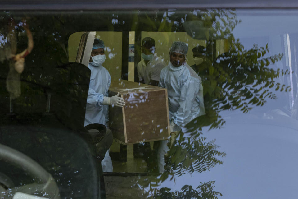 Healthcare workers carry the body of a person who died in Friday's train accident in Balasore, into an ambulance at the All India Institute of Medical Sciences hospital in Bhubaneswar in the eastern state of Orissa, India, Monday, June 5, 2023. Families of the victims of India's deadliest train crash in decades filled the hospital on Monday to identify and collect bodies of relatives, as railway officials recommended the country's premier criminal investigating agency to probe the crash that killed 275 people. (AP Photo/Rafiq Maqbool)