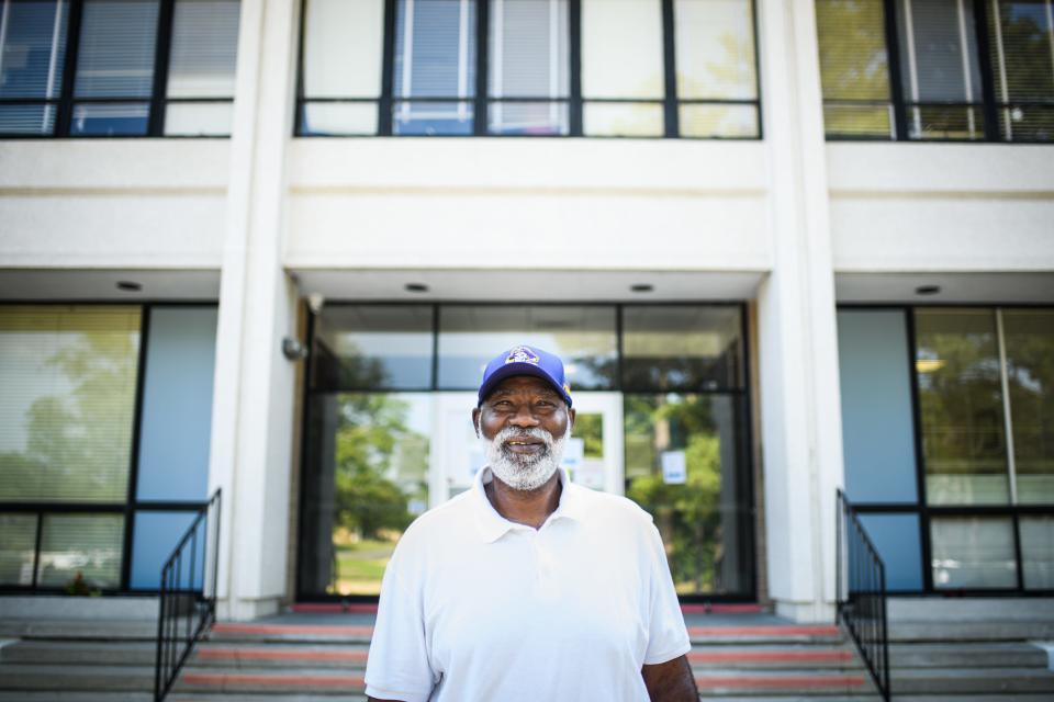 Former NFL player Reggie Pinkney stands in front of Reid Ross Classical School, where he graduated from in 1973 when it was called Reid Ross High School.