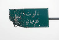 A damaged road sign reading "Nalot -Garyan" is seen in Al Hira area, south western Tripoli, Libya April 23, 2019. REUTERS/Hani Amara