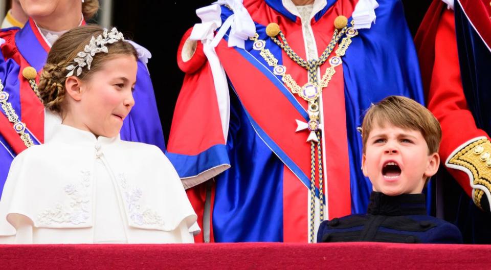 TOPSHOT - Britain's Princess Charlotte of Wales and Britain's Prince Louis of Wales stand on the Buckingham Palace balcony as they wait for the Royal Air Force fly-past in central London on May 6, 2023, after the coronations of King Charles III and Queen Camilla. - The set-piece coronation is the first in Britain in 70 years, and only the second in history to be televised. Charles will be the 40th reigning monarch to be crowned at the central London church since King William I in 1066. Outside the UK, he is also king of 14 other Commonwealth countries, including Australia, Canada and New Zealand. Camilla, his second wife, was crowned Queen alongside him. (Photo by Leon Neal / POOL / AFP) (Photo by LEON NEAL/POOL/AFP via Getty Images)