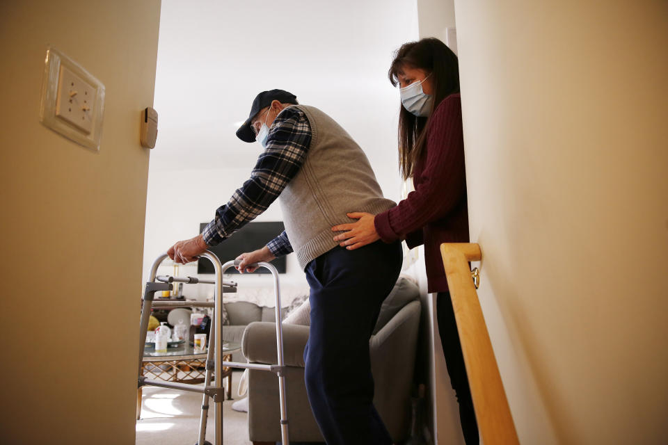 A home health care aide steadies her client inside his home in Peabody, Massachusetts on Jan. 25, 2021. Ever since the 2020 presidential campaign, Joe Biden has talked about having the government spend a lot more on caregiving ― for children, older adults and disabled people. (Photo: Jessica Rinaldi/The Boston Globe via Getty Images)