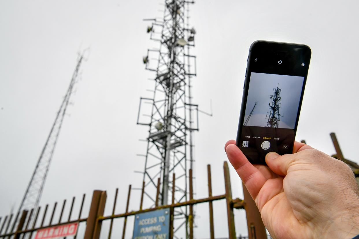 A mobile phone next to a telecoms mast (PA Archive)