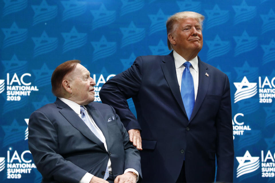 President Donald Trump pats Las Vegas Sands Corporation Chief Executive and Republican mega donor Sheldon Adelson on the arm before speaking at the Israeli American Council National Summit in Hollywood, Fla., Saturday, Dec. 7, 2019. (AP Photo/Patrick Semansky)