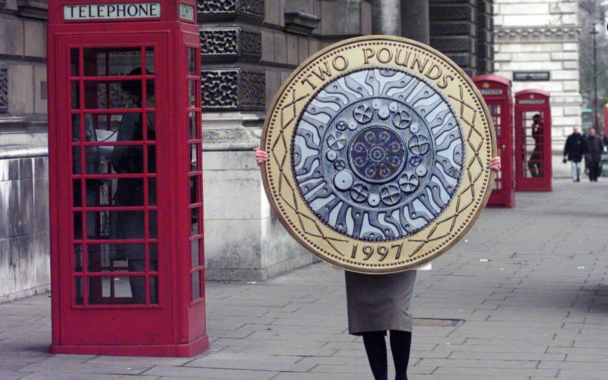 A cardboard replica of the new Two pound sterling coin is carried to the Treasury Dept - AP Photo/Lynne Sladky