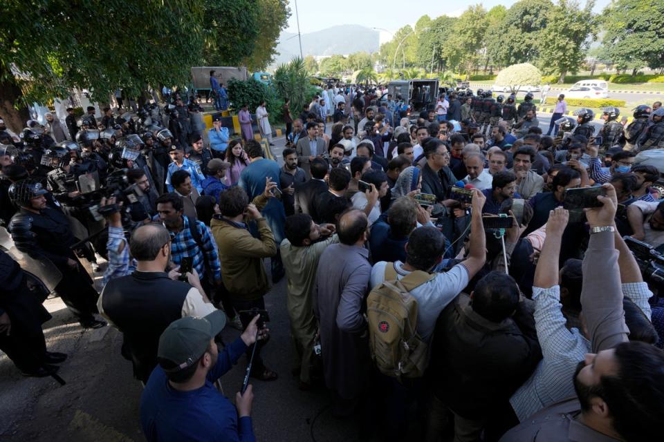 Police attempt to stop supporters of the PTI party from entering the Election Commission head office in Islamabad (AP)