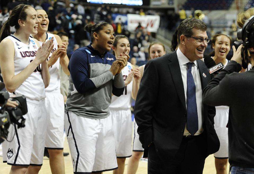 The Connecticut team sings Happy Birthday behind head coach Geno Auriemma, right, as he is interviewed on live television after their 87-44 win over Prairie View A&M in a first-round game of the NCAA women's college basketball tournament, Sunday, March 23, 2014, in Storrs, Conn. Today is Auriemma's 60th birthday. (AP Photo/Jessica Hill)