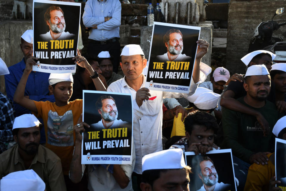 Congress supporters hold placards with a picture of the