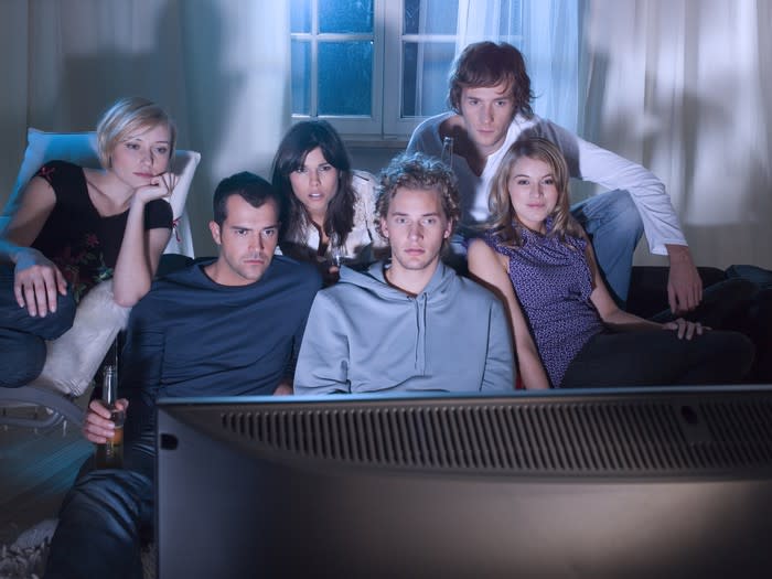 A group of young people watching TV