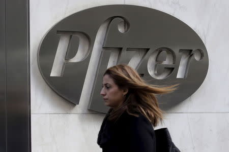 A woman passes by the Pfizer World Headquarters building in the Manhattan borough of New York, November 23, 2015. REUTERS/Brendan McDermid