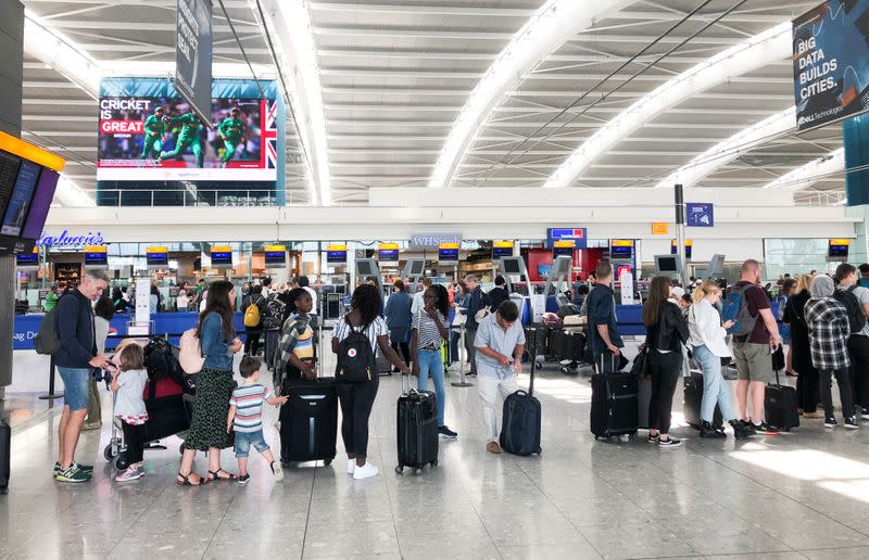 People queue inside Terminal 5 at Heathrow Airport as IT problems caused delays in London