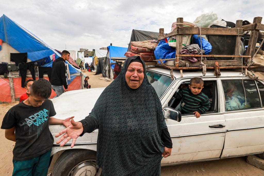 A woman cries out as she stands before a vehicle loaded with items as people flee from Rafah in the southern Gaza Strip on Feb.13, 2024.