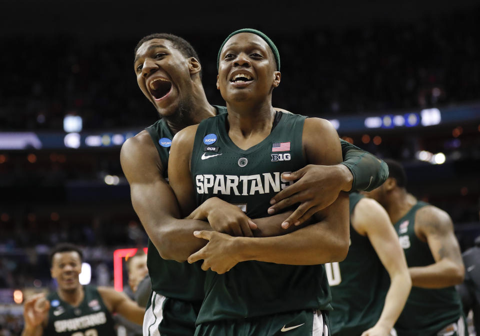 Michigan State guard Cassius Winston (5) is hugged by teammate forward Aaron Henry (11) after defeating Duke in an NCAA men's East Regional final college basketball game in Washington, Sunday, March 31, 2019. Michigan State won 68-67. (AP Photo/Patrick Semansky)