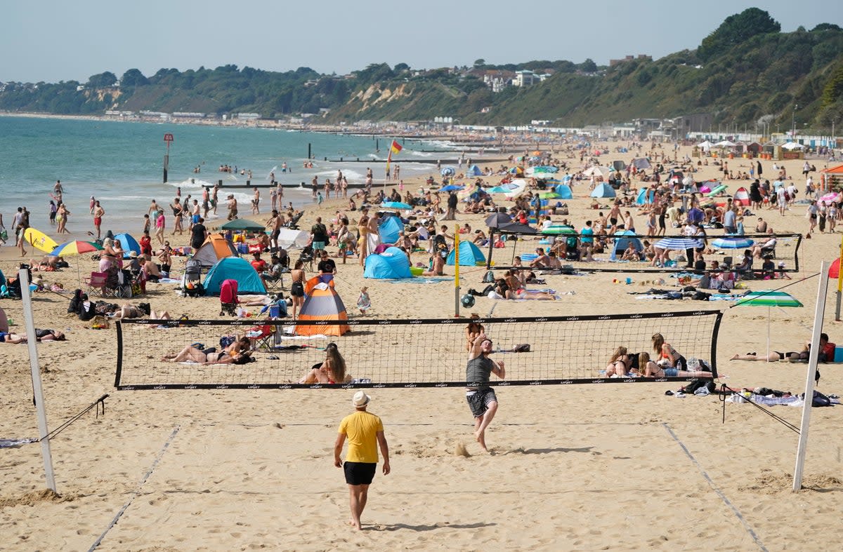 People enjoy the hot weather on Bournemouth beach  (Andrew Matthews / PA)