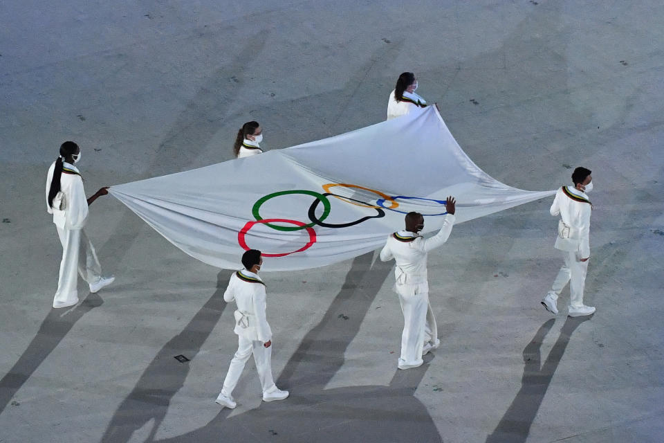 <p>An overview shows the Olympic flag being carried during the opening ceremony of the Tokyo 2020 Olympic Games, at the Olympic Stadium, in Tokyo, on July 23, 2021. (Photo by Antonin THUILLIER / AFP) (Photo by ANTONIN THUILLIER/AFP via Getty Images)</p> 