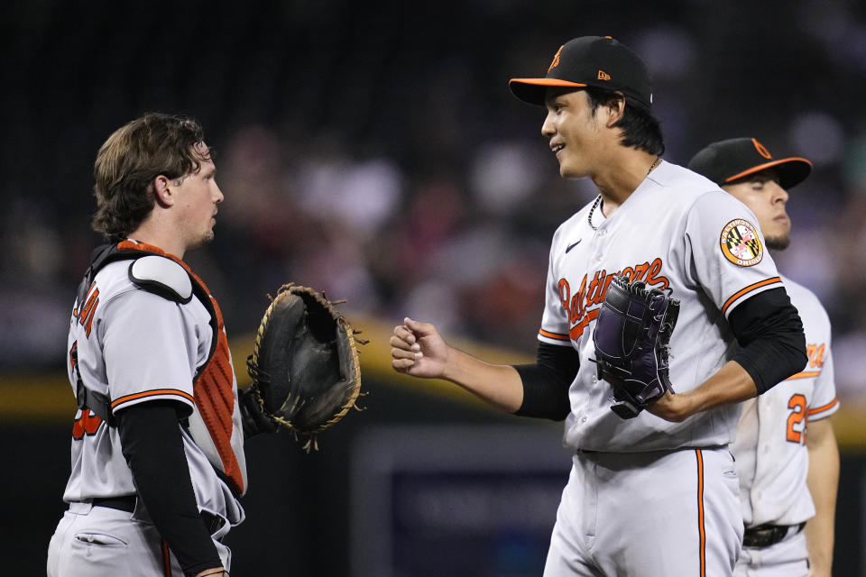 Baltimore Orioles relief pitcher Shintaro Fujinami, right, talks with catcher Adley Rutschman during the eighth inning of the team's baseball game against the Arizona Diamondbacks Friday, Sept. 1, 2023, in Phoenix. The Diamondbacks won 4-2. (AP Photo/Ross D. Franklin)
