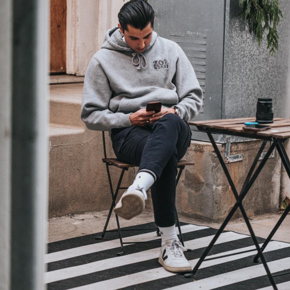 man in gray sweater sitting on brown wooden folding table