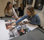 Classmates Faith Robinson, left, and Chloe Stephens, right, place photos of Walker Vincent on a board during a 16th birthday party for Walker at Leslie Jacob's home on Sunday, December 29, 2019 in Lafayette, La. Walker Vincent was one of the victims in the plane crash on Saturday. Family and friends threw him a birthday party where they released LSU balloons and marked gifts with their favorite memories of Walker for his father. (Brad Kemp/The Advocate via AP)