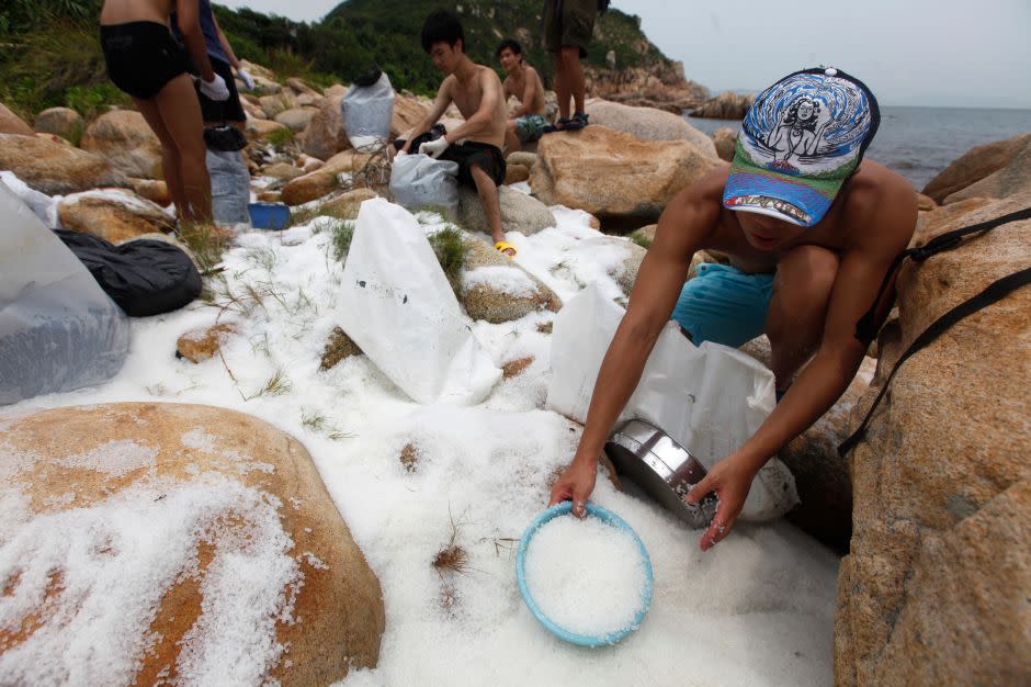 In this photo, volunteers are cleaning nurdles on the coast of Hong Kong's Lamma island in 2012. Hundreds of millions of the plastic pellets were dumped when containers knocked off a vessel during a typhoon.