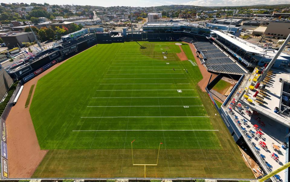 Workers paint yard lines and school names as they get Polar Park ready to host football games for Holy Cross, Assumption and Worcester Tech/Assabet this weekend.