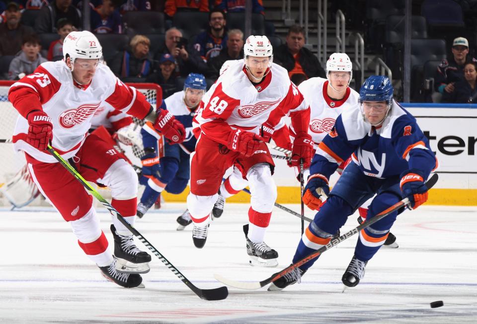 Adam Erne and Alex Chiasson of the Detroit Red Wings skates against Noah Dobson of the New York Islanders during the first period at UBS Arena in Elmont, New York, on Saturday, March 4, 2023.