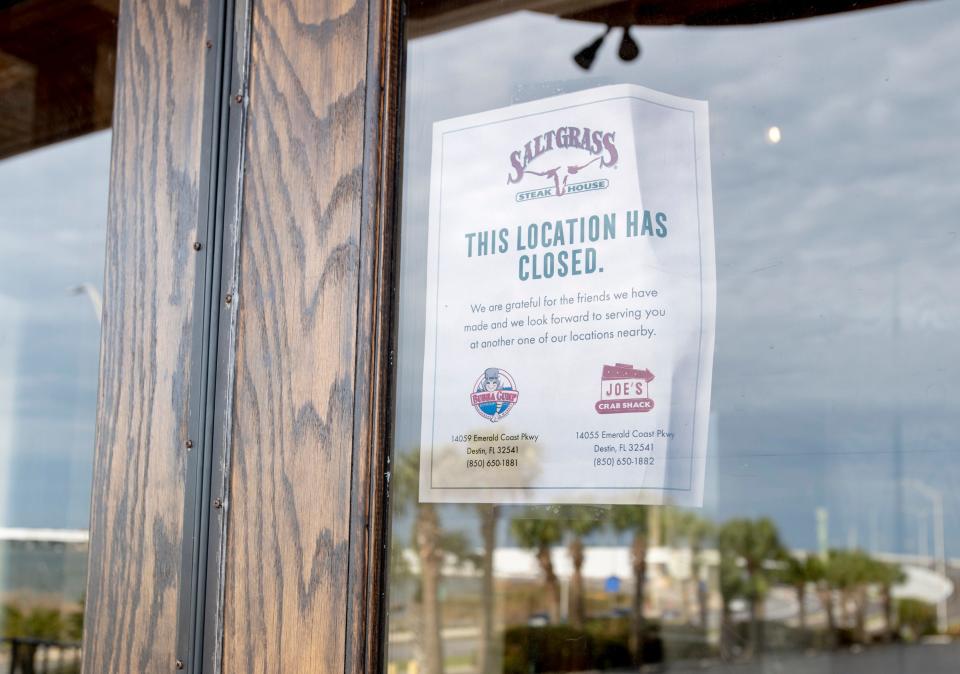 A sign on the door at Saltgrass Steak House informs customers that the Pensacola location has permanently closed.