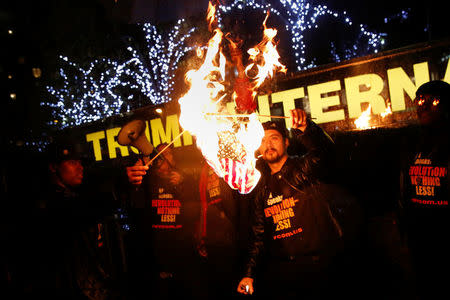 Supporters of the "NYC Revolution Club" burn the U.S. flag outside the Trump International Hotel and Tower in New York, U.S., November 29, 2016. REUTERS/Shannon Stapleton