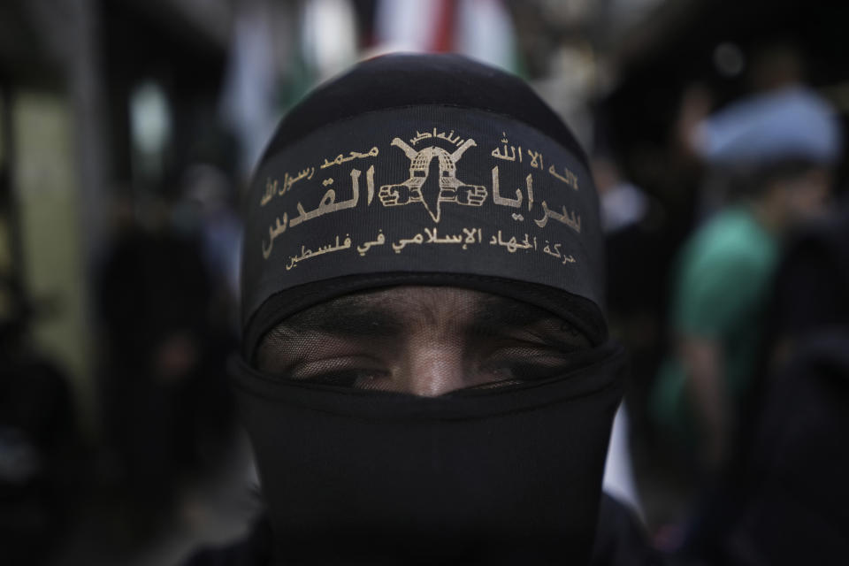 A Palestinian member of Al-Quds Brigades, the military wing of the Islamic Jihad group walks during a protest in solidarity with the Palestinian people in Gaza, at the Palestinian refugee camp of Chatila in Beirut, Lebanon, Saturday, May 11, 2024. The Arabic on his headband reads: "No God but Allah and Muhammed is his messenger, top, Al-Quds Brigades, center, and The Islamic Jihad movement in Palestine." (AP Photo/Hassan Ammar)