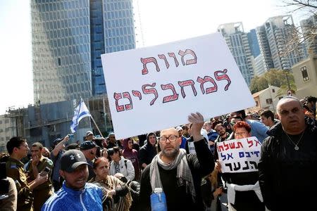 A protester holds a placard, with Hebrew text reading "death to terrorists", as they demonstrate in support of Israeli soldier Elor Azaria, outside a military court in Tel Aviv, Israel February 21, 2017. REUTERS/Baz Ratner