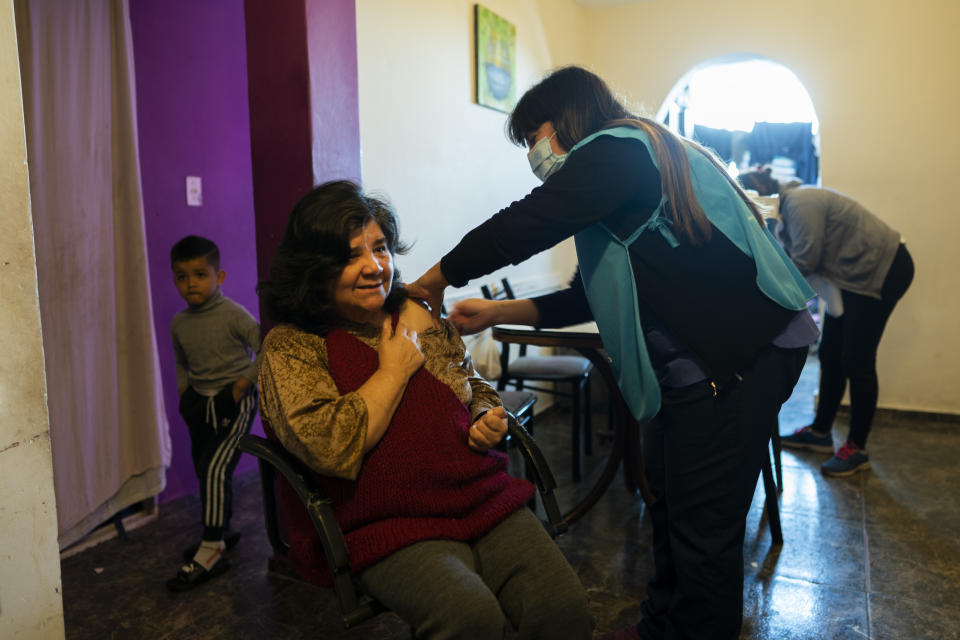 A nurse vaccinates Blas Ignacia Galeano, 58, with a dose of the Sinopharm COVID-19 vaccine in the Fuerte Apache neighborhood in Buenos Aires province, Argentina, Wednesday, Aug. 18, 2021. Galeano suffered a stroke several years ago and can't walk down the eight floors of her apartment building to get to the vaccination center. As vaccination rates fall in the densely populated province of Buenos Aires which holds a third of the country's population authorities began a a door-to-door vaccination campaign Wednesday in an effort to ramp up immunization in the face of growing caseloads of the Delta variant. (AP Photo/Victor R. Caivano)