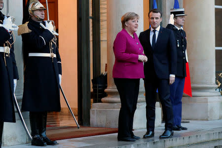 French President Emmanuel Macron (R) greets German Chancellor Angela Merkel upon her arrival at the Elysee Palace in Paris, France, January 19, 2018. REUTERS/Charles Platiau