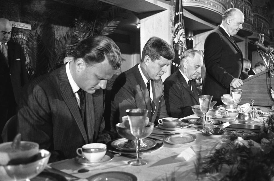 <p>President John F. Kennedy and others at the head table bow their heads during the invocation at the annual “Presidential prayer breakfast” in a Washington hotel, Feb. 9, 1961. From left: Billy Graham, Kennedy; Sen. Frank Carlson, R-Kan., and Judge Boyd Leedom of Washington, president of the International Christian Leadership Conference, the sponsoring organization. (Photo: Henry Burroughs/AP) </p>