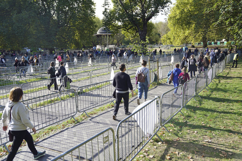 People arrive at the end of the queue to pay their respects to Queen Elizabeth II lying in state, in Southwark Park, in London, Sunday, Sept. 18, 2022. Hundreds of thousands of people are expected to pack central London for an service attend by 500 emperors, kings, queens, presidents, prime ministers and other leaders from around the world. London's Metropolitan Police says the “hugely complex” policing operation is the biggest in the force’s history, surpassing the London 2012 Olympics. (James Manning/PA via AP)