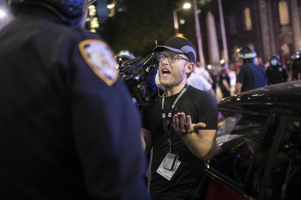 Associated Press videojournalist Robert Bumsted reminds a police officer that the press are considered “essential workers" and are allowed to be on the streets despite a curfew, Tuesday, June 2, 2020, in New York. New York City police officers surrounded, shoved and yelled expletives at two Associated Press journalists covering protests in the latest aggression against members of the media during a week of unrest around the country. Portions of the incident were captured on video by Bumsted, who was working with photographer Wong Maye-E to document the protests in lower Manhattan over the killing of George Floyd in Minneapolis.(AP Photo/Wong Maye-E)