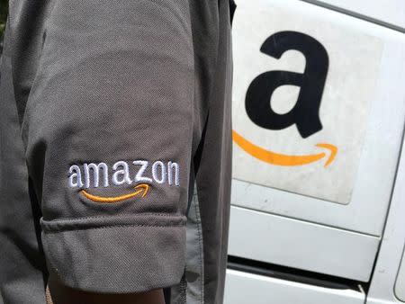 An Amazon.com Inc driver stands next to an Amazon delivery truck in Los Angeles, California, U.S., May 21, 2016. REUTERS/Lucy Nicholson/Files