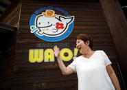 Yachiyo Ichihara, 72, waves to her friends at a roadside store featuring local whale products named WA-O! in Minamiboso