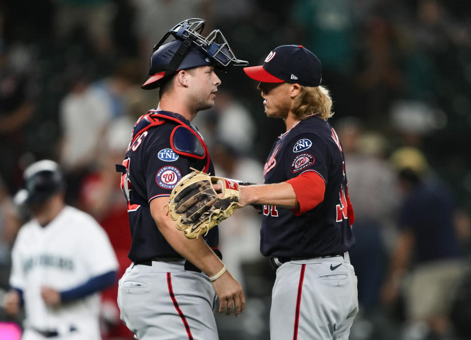 Washington Nationals catcher Riley Adams, left, greets relief pitcher Jordan Weems after the team's 7-4 win over the Seattle Mariners in 11 innings in a baseball game Tuesday, June 27, 2023, in Seattle. (AP Photo/Lindsey Wasson)