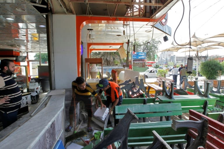 Local residents check their shops in Baghdad's Karrada district in the aftermath of a car bomb explosion on May 30, 2017