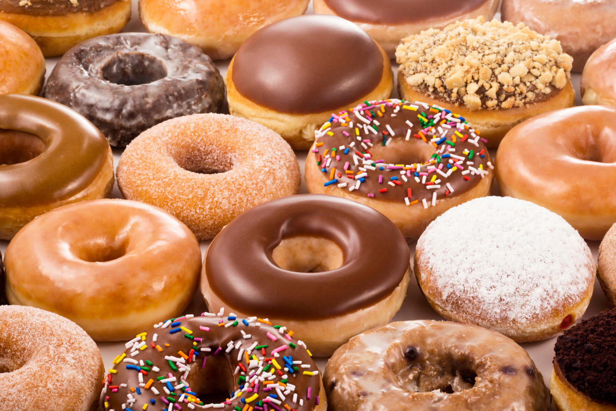 A group of assorted donuts of various flavors, some with sprinkles