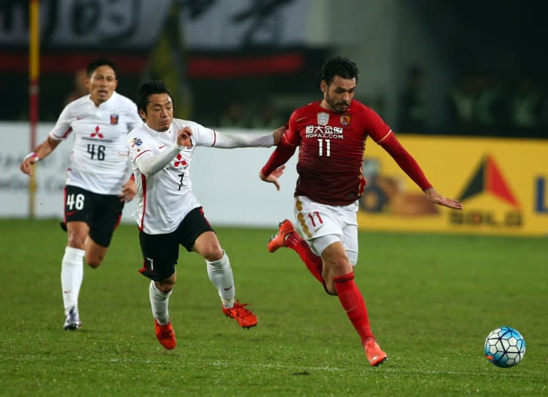 Ricardo Goulart (R) of China's Guangzhou Evergrande fights for the ball with Umesaki Tsukasa (C) of Japan's Urawa Red Diamonds during their AFC Champions League group stage football match in Guangzhou, in China's Guangdong province on March 16, 2016