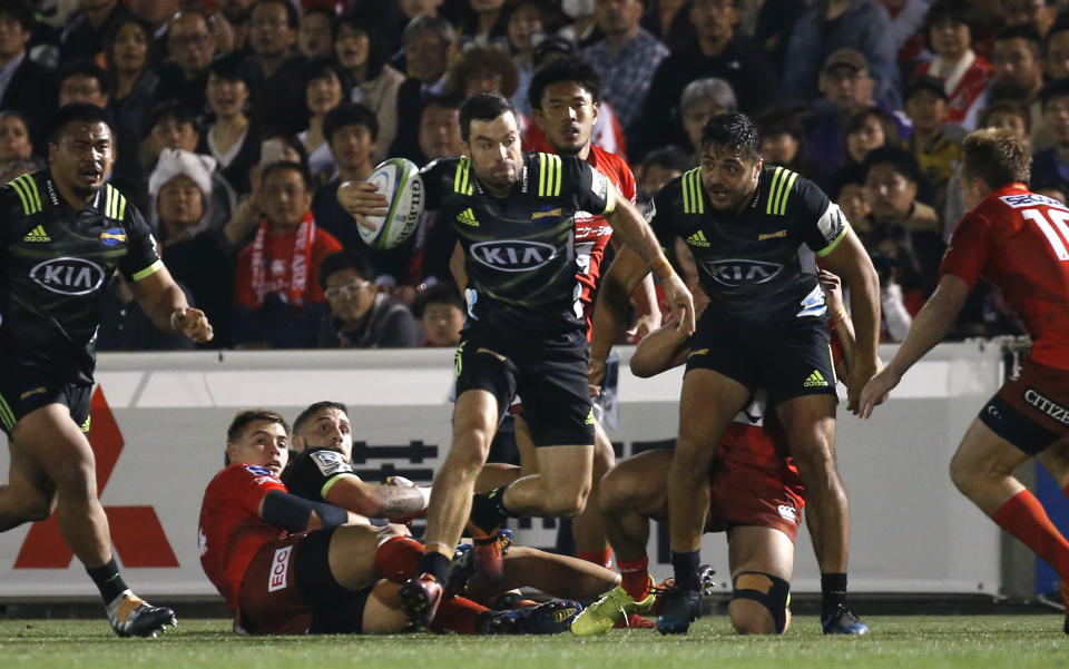 Hurricane's Asafo Aumua, center, runs at the Sunwolves defense during the Super Rugby game between the Hurricanes and Sunwolves in Tokyo, Friday, April 19, 2019. (AP Photo/Shuji Kajiyama)