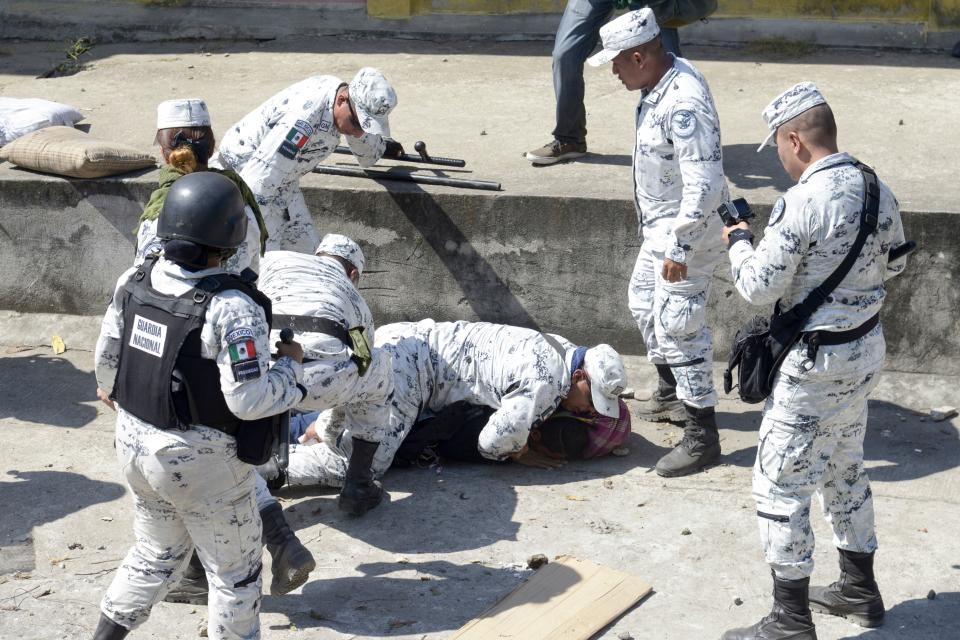 A Central American migrant - part of a group of mostly Hondurans travelling on caravan to the US- is detained by a member of Mexico's National Guard  after crossing the Suchiate River, the natural border between Tecun Uman in Guatemala and Ciudad Hidalgo in Mexico, on January 20, 2020. - Hundreds of Central Americans from a new migrant caravan tried to enter Mexico by force Monday by crossing the river that divides the country from Guatemala, prompting the National Guard to fire tear gas, an AFP correspondent said. (Photo by ISAAC GUZMAN / AFP) (Photo by ISAAC GUZMAN/AFP via Getty Images)