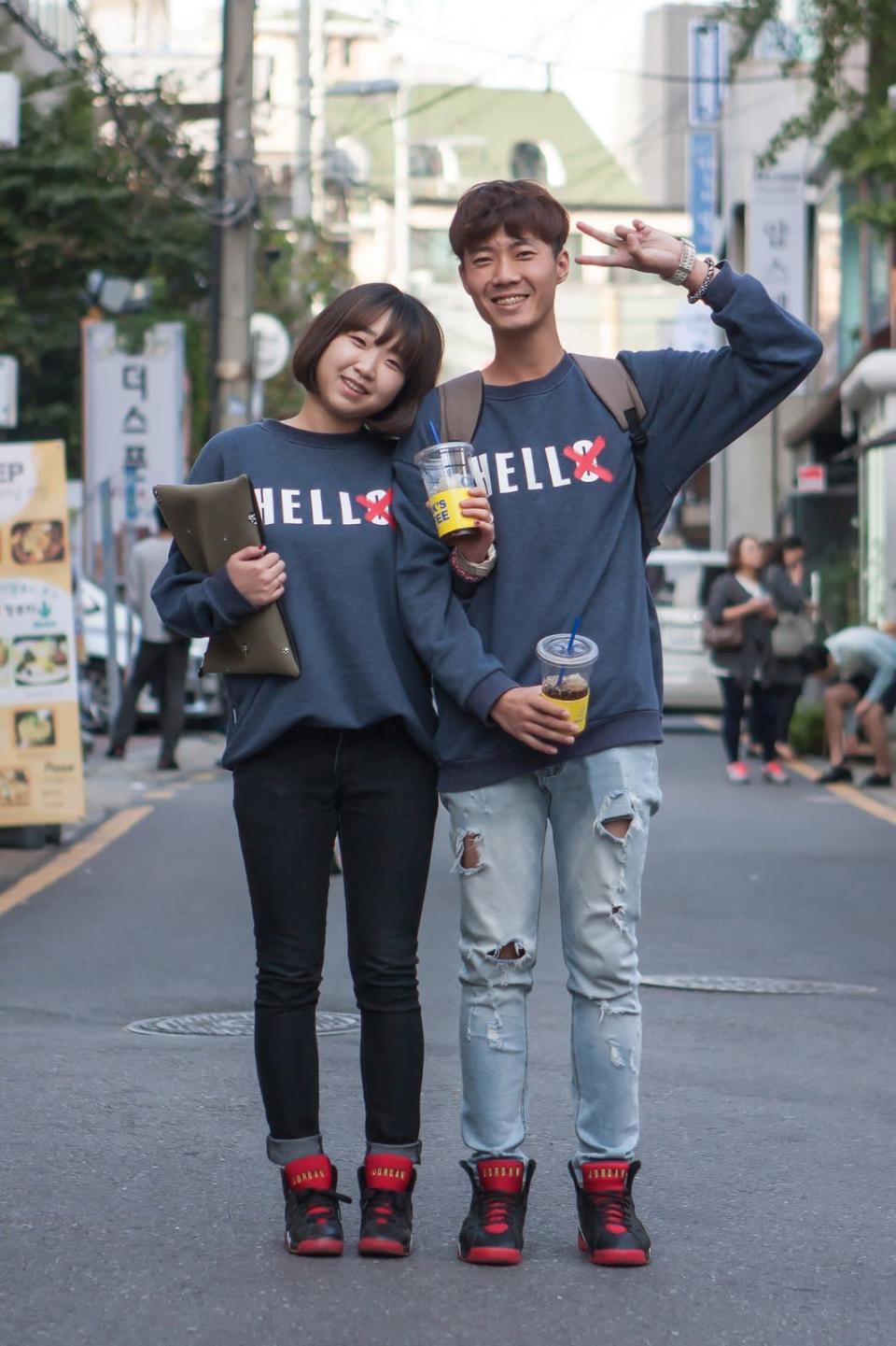 This couple coordinated their “Hello” sweatshirts and red sneakers but wore different jeans and carried mismatching bags at Seoul Fashion Week. 