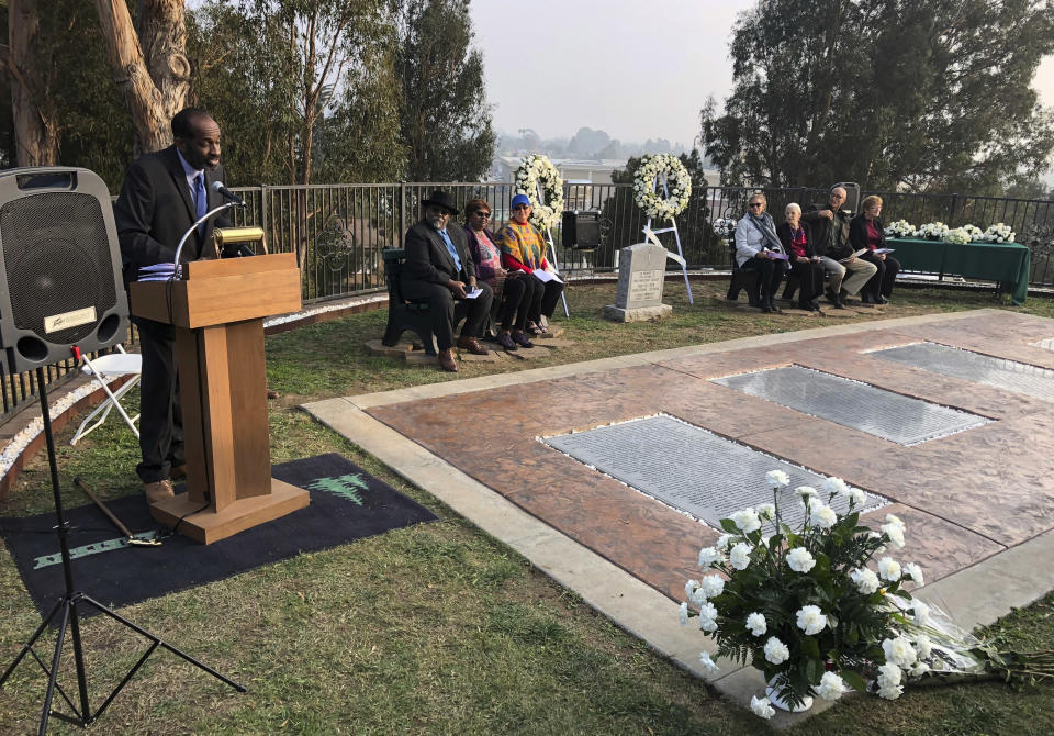 Jim Jones Jr., the adopted black son of the Rev. Jim Jones, speaks to a service for the 40th Jonestown anniversary at Evergreen Cemetery in Oakland, Calif., Sunday, Nov. 18, 2018. Ceremonies at the California cemetery marked the mass murders and suicides 40 years ago of 900 Americans orchestrated by the Rev.Jones at a jungle settlement in Guyana, South America. (AP Photo/Tim Reiterman)