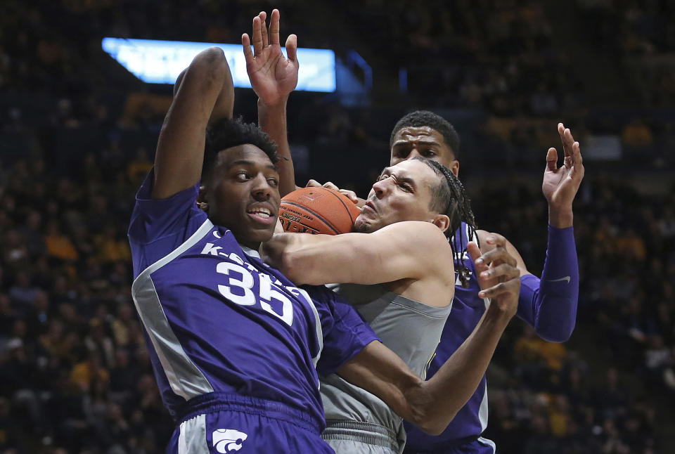 West Virginia forward Patrick Suemnick, center, is defended by Kansas State forwards Nae'Qwan Tomlin (35) and David N'Guessan, right, during the first half of an NCAA college basketball game on Saturday, March 4, 2023, in Morgantown, W.Va. (AP Photo/Kathleen Batten)