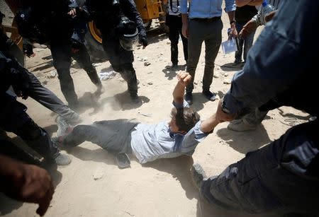 Israeli policemen detain a protester in the Palestinian Bedouin village of al-Khan al-Ahmar near Jericho in the occupied West Bank July 4, 2018. REUTERS/Mohamad Torokman