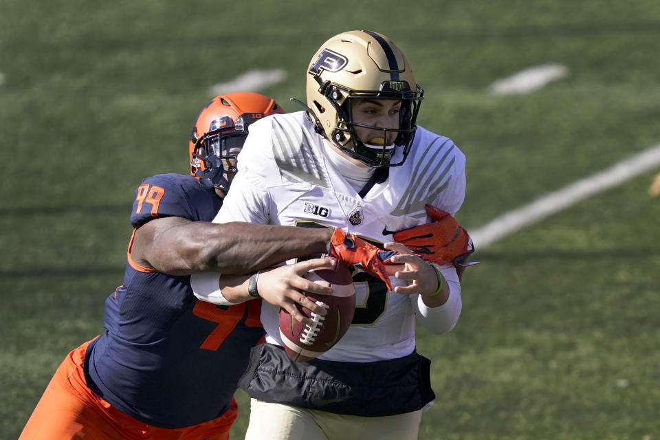 Illinois defensive lineman Owen Carney Jr., left, strips Purdue quarterback Aidan O'Connell of the ball during the first half of an NCAA college football game Saturday, Oct. 31, 2020, in Champaign, Ill. (AP Photo/Charles Rex Arbogast)