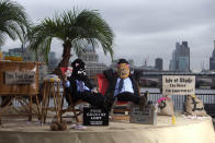  EDITORIAL USE ONLYLuke Harman (left) and Mark Webber, dressed as 'fat-cats', sit on The Isle of Shady, a pop-up tax haven set up by Enough Food for Everyone IF campaigners, sits on the South Bank of the river Thames at Gabriel's Wharf in London ahead of the Open for Growth: Tax, Trade and Transparency event on 15th June and the G8 summit. PRESS ASSOCIATION Picture date: Friday June 14, 2013. Enough Food for Everyone IF is a coalition of more than 200 organisations working together to ensure that governments tackle causes of the global hunger crisis in the year that the UK Government hosts the G8 leaders. Photo credit should read: David Parry/PA Wire 